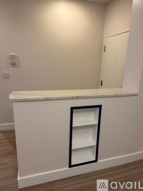 A white counter with a black framed opening in the middle.