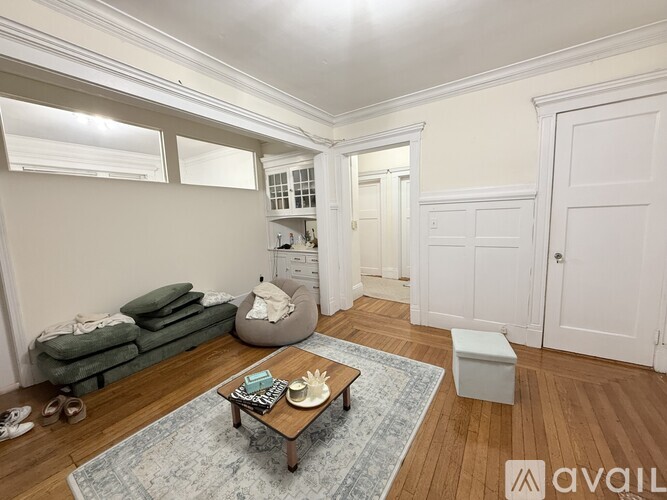 A living room with a couch, coffee table, and a rug.