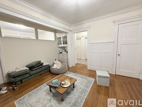A living room with a couch, coffee table, and a rug.