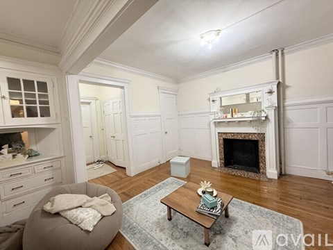 A living room with a fireplace and a grey armchair.