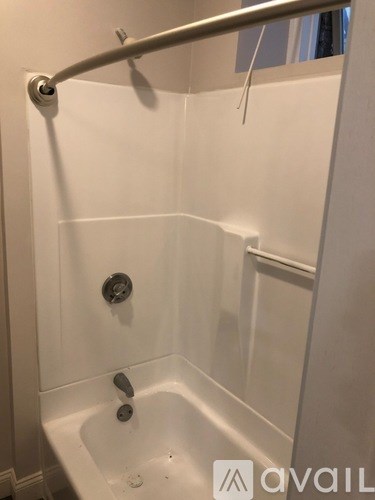A white bathtub with a silver faucet and a silver grab bar.