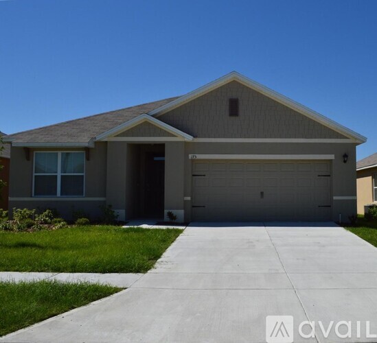 A house with a grey roof and a garage door.