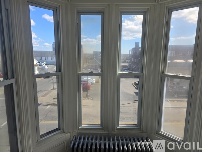 A window with a view of a street and buildings.