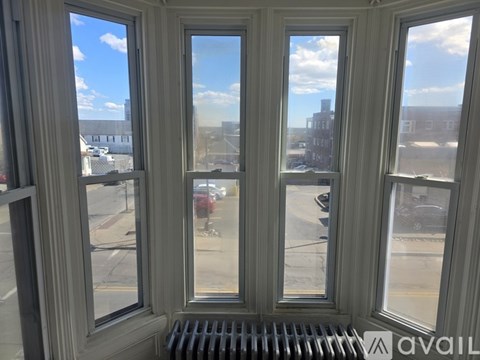 A window with a view of a street and buildings.