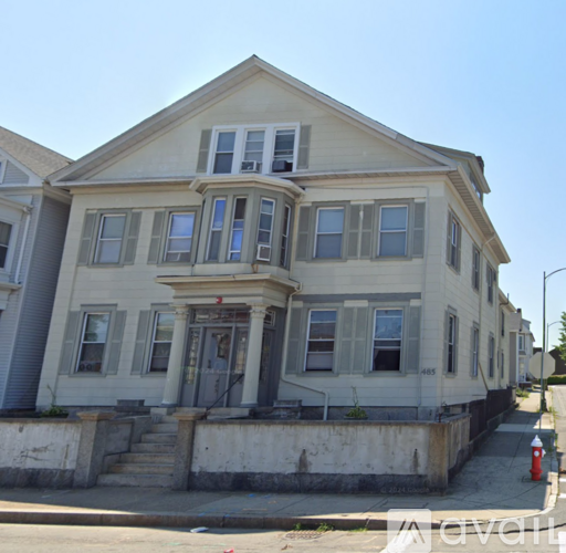 A two-story house with a grey facade and a red fire hydrant in front.