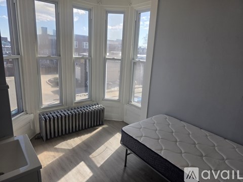A bedroom with a large bed and a radiator.