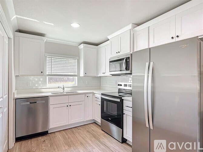 A kitchen with white cabinets and stainless steel appliances.