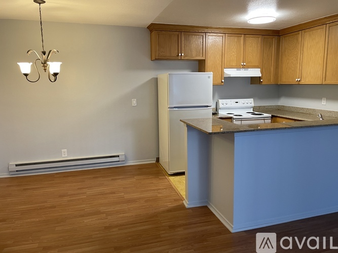 A kitchen with a white refrigerator and wooden cabinets.