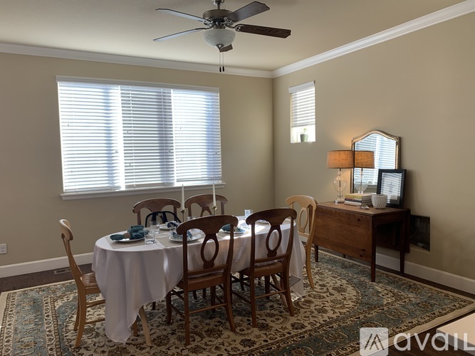 A dining room with a round table set for six.