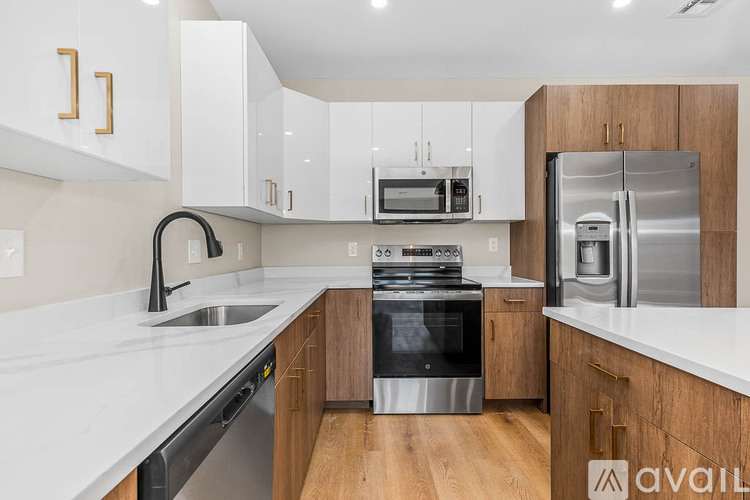 A kitchen with white cabinets and a stainless steel refrigerator.