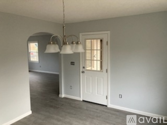 A room with a white door and a light fixture.