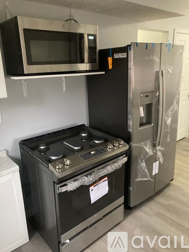 A black stove and refrigerator in a kitchen.