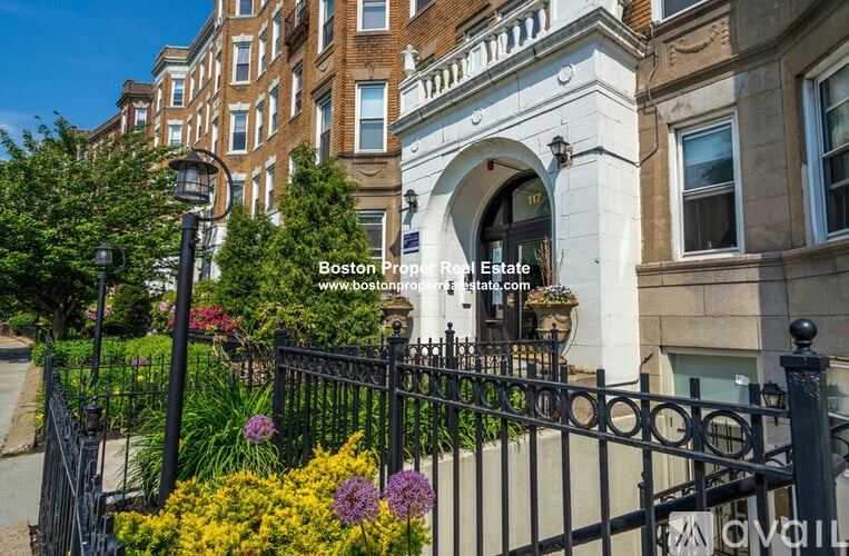 A black iron fence surrounds a building entrance.