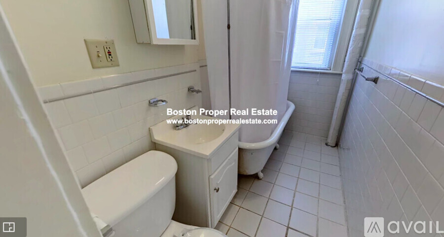 A white bathroom with a toilet, sink, and tub.