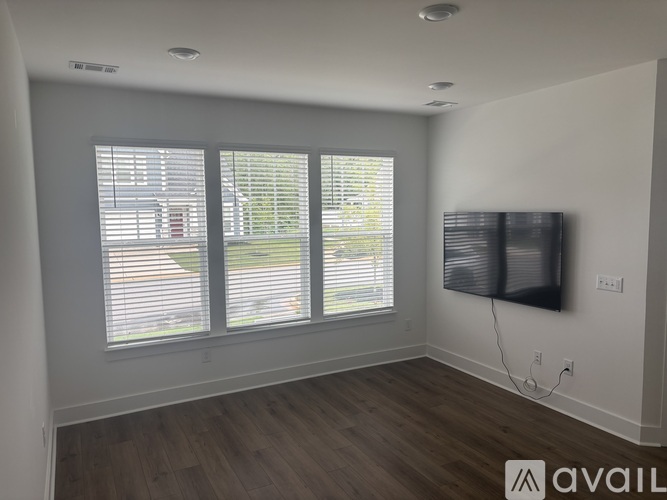 A room with a large window and a flat screen TV mounted on the wall.