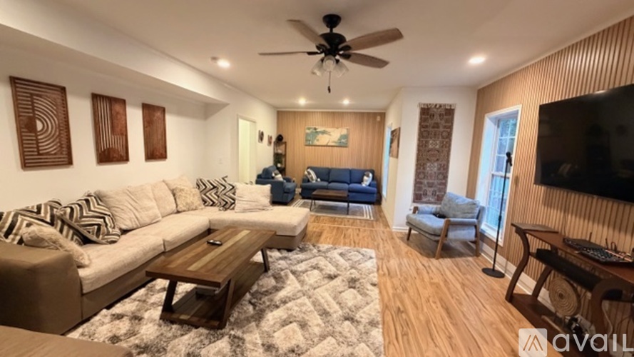 A living room with a white couch and a wooden coffee table.