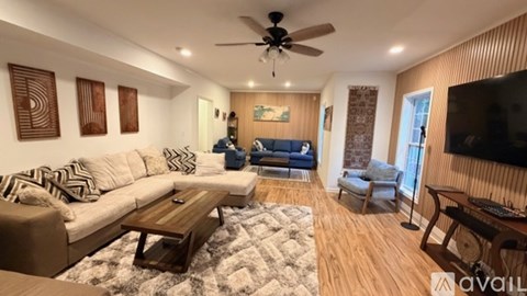 A living room with a white couch and a wooden coffee table.