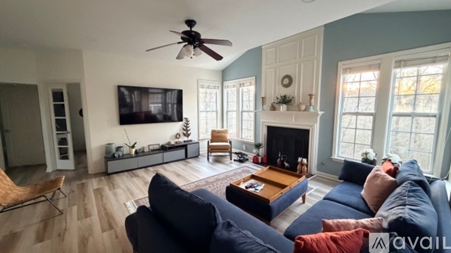 A living room with a blue couch and a fireplace.