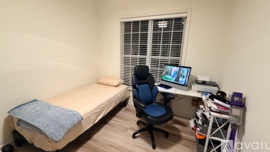 A small room with a bed, desk, and chair.