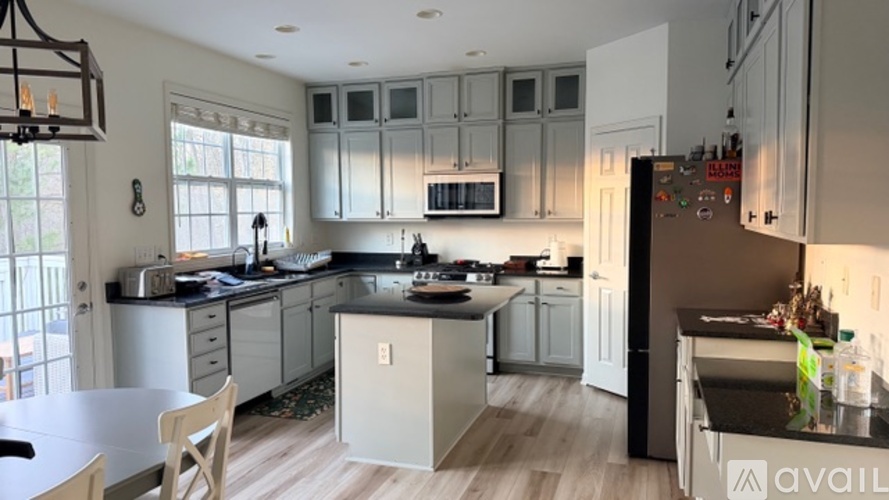 A kitchen with white cabinets and a black countertop.