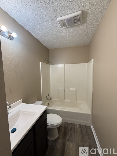 A white bathroom with a towel rack and a bathtub.
