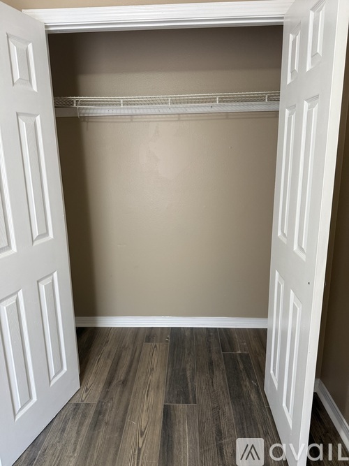 A white closet with a white door and a white shelf.