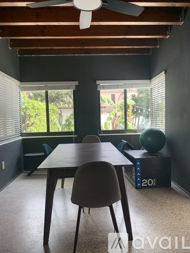A room with a table, chairs and a ceiling fan.