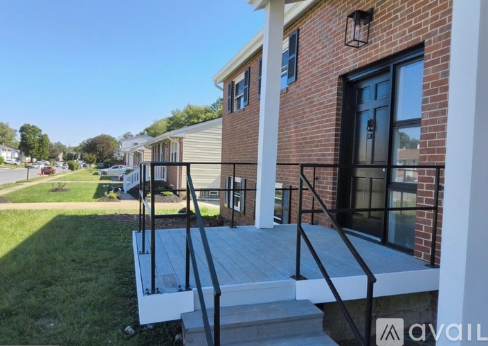 A house with a brick exterior and a black door is for sale.