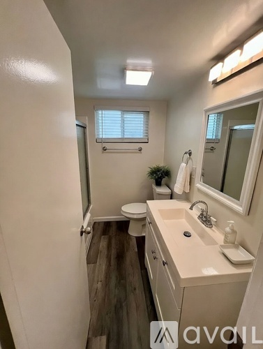 A bathroom with a white sink and a toilet.