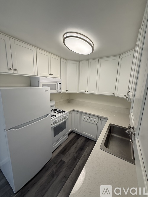 A kitchen with white appliances and cabinets.