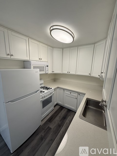 A kitchen with white appliances and cabinets.