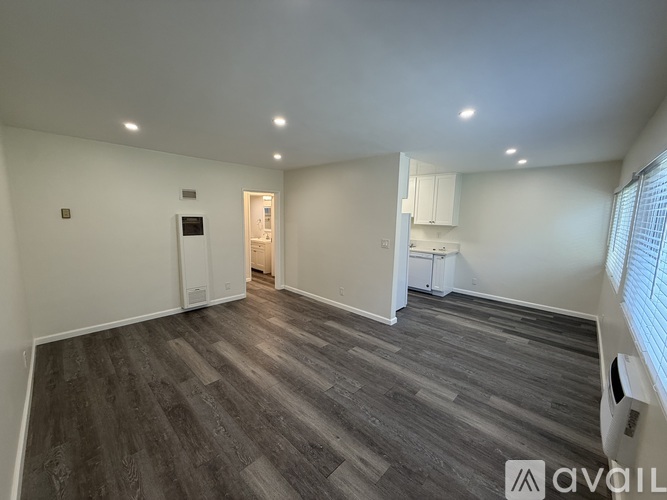 A spacious room with grey flooring and white walls.