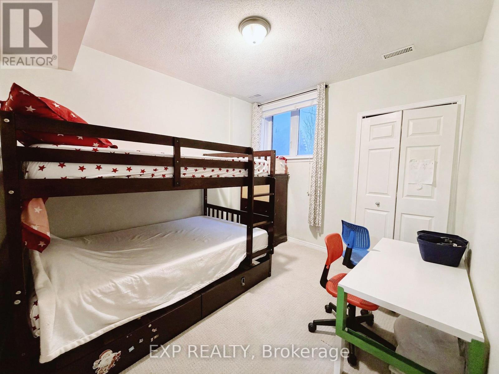 A bedroom with a bunk bed and a desk.