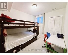 A bedroom with a bunk bed and a desk.