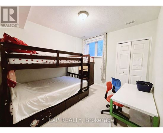 A bedroom with a bunk bed and a desk.