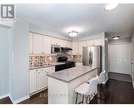 A kitchen with white cabinets and a tile backsplash.