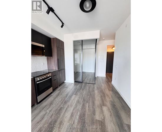 A modern kitchen with dark wood cabinets and a stainless steel oven.