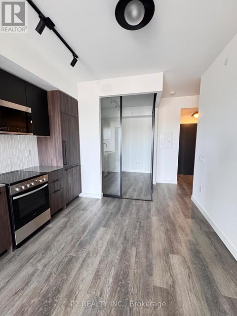 A modern kitchen with dark wood cabinets and a stainless steel oven.