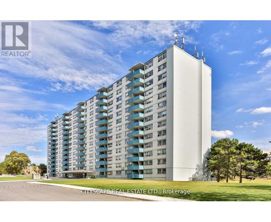 A tall residential building with a clear blue sky in the background.