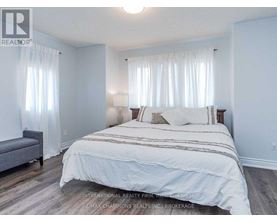 A bedroom with a large bed and a grey sofa.