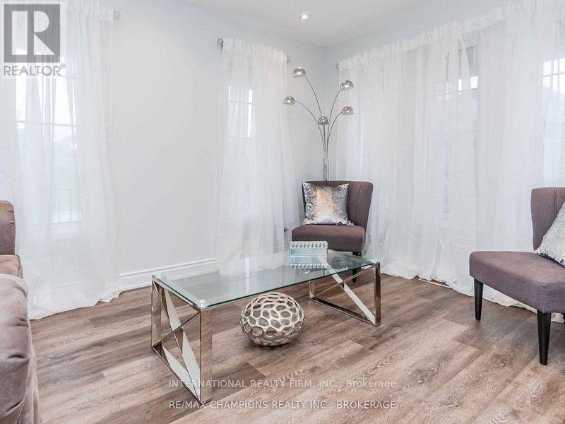 A modern living room with a glass coffee table and two chairs.