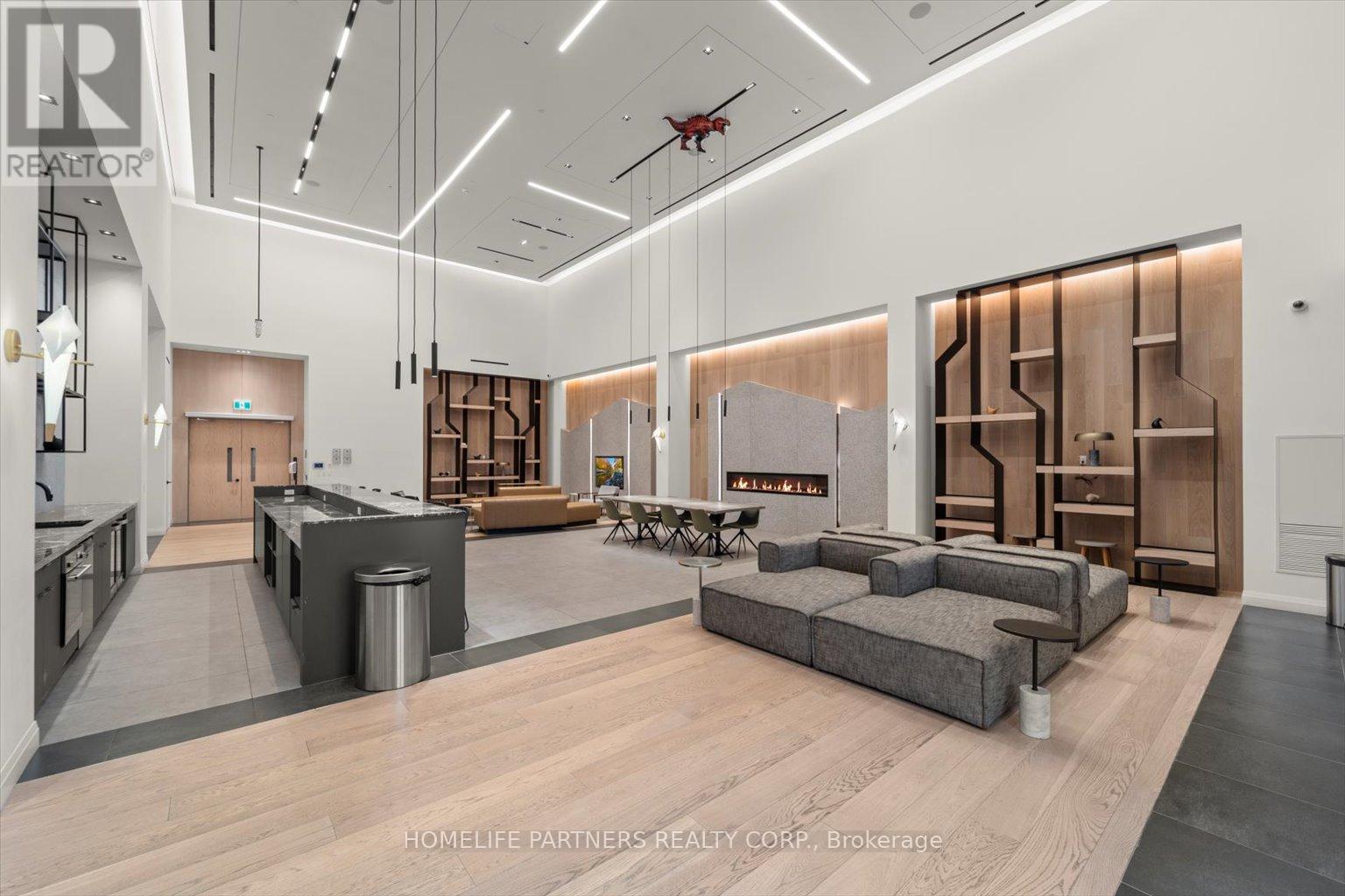 A modern living room with a grey sofa and wooden floors.