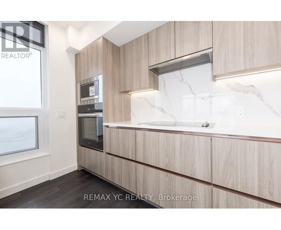 A modern kitchen with wooden cabinets and a marble backsplash.