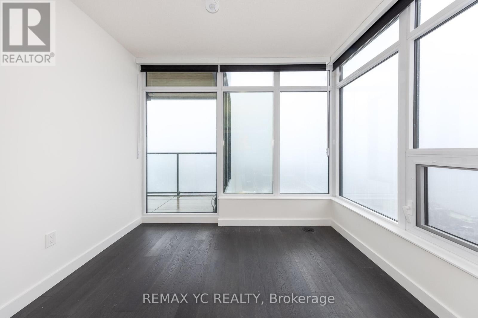 A room with a large window and a wooden floor.