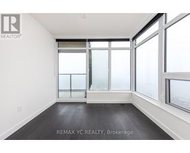 A room with a large window and a wooden floor.