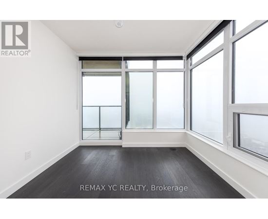 A room with a large window and a wooden floor.