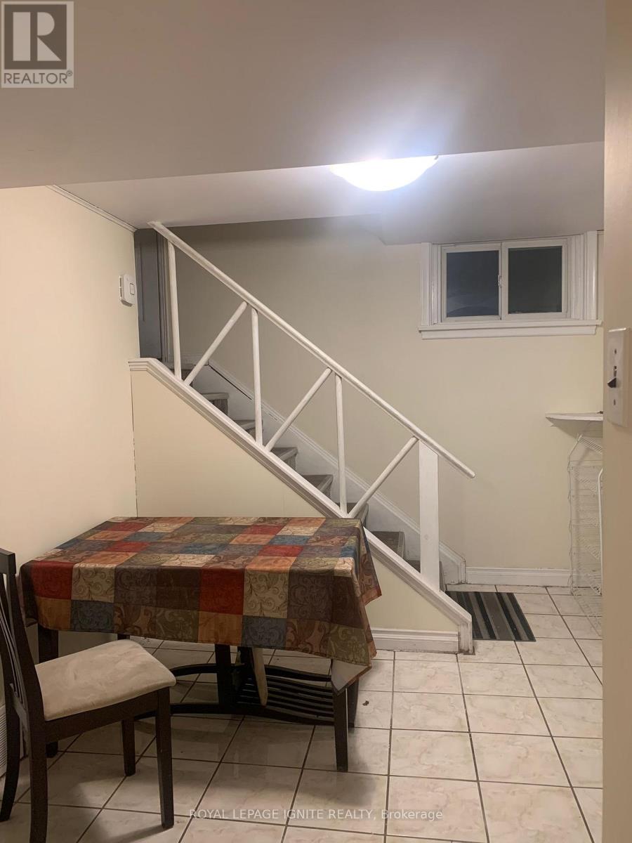 A room with a staircase and a table with a chair.