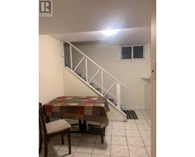 A room with a staircase and a table with a chair.