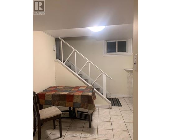 A room with a staircase and a table with a chair.