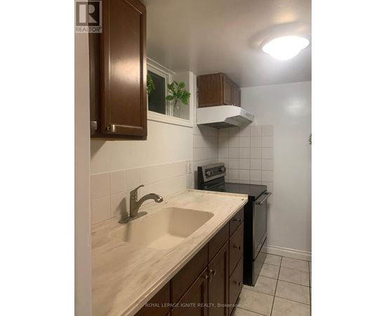 A kitchen with a sink and a stove top oven.